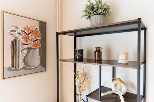a shelf with vases on it next to a wall at T4 Spacieux et lumineux Joeuf in Joeuf