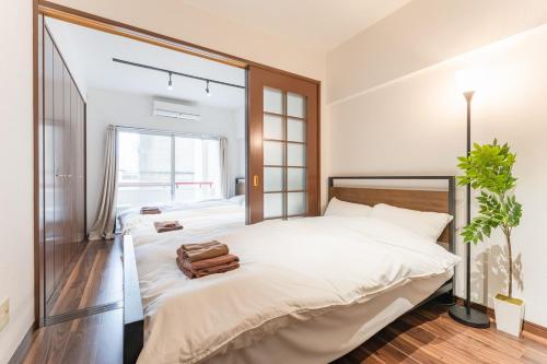a bedroom with a large white bed and a window at Shibuya E-address 205 in Tokyo