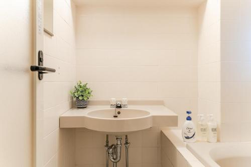 a white bathroom with a sink and a tub at Shibuya E-address 205 in Tokyo