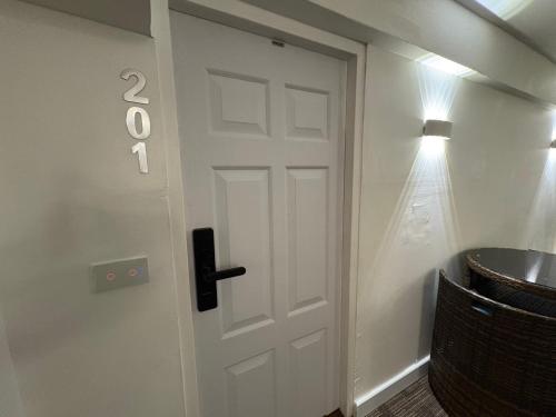 a white door in a room with a lamp at The White Den Sukhumvit 44 in Bangkok