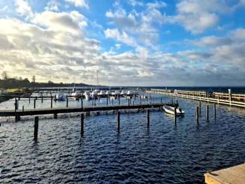 a dock with boats in the water under a cloudy sky at Tranquil Retreat in Hejlsminde-By Traum in Hejls