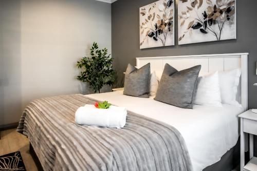 a bedroom with a large white bed with pillows at Whale Coast Ocean Villa in Hermanus