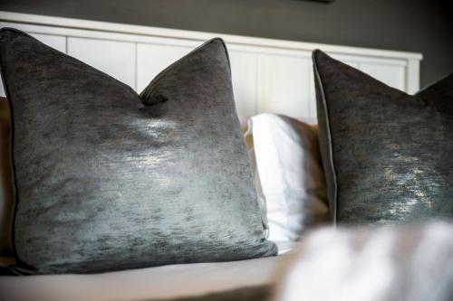 a pair of pillows sitting on top of a bed at Whale Coast Ocean Villa in Hermanus