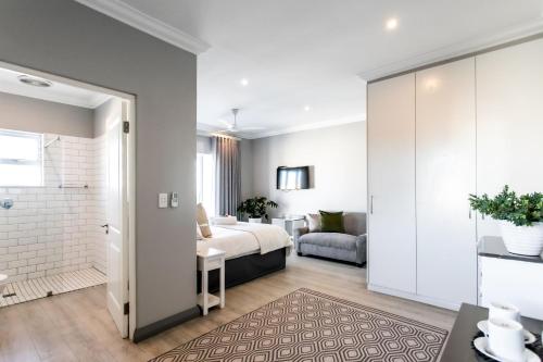 a bedroom with a bed and a bathroom at Whale Coast Ocean Villa in Hermanus