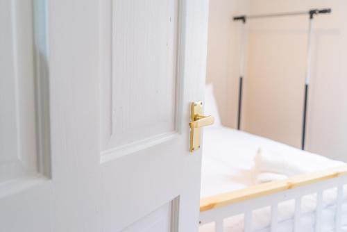 a bathroom door with a sink and a mirror at Victoria Retreat in Workington