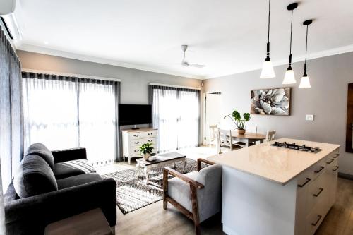 a living room with a kitchen and a living room with a table at Whale Coast Ocean Villa in Hermanus