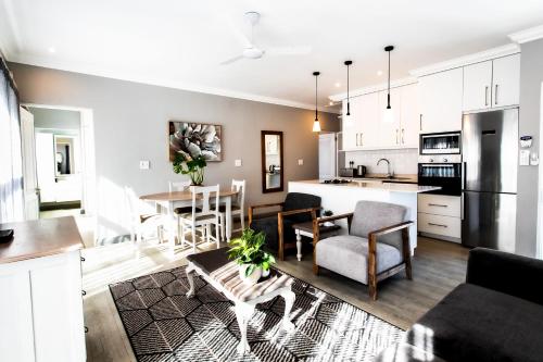 a kitchen and living room with a table and chairs at Whale Coast Ocean Villa in Hermanus