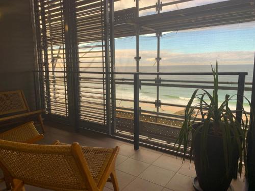 a room with a window with a view of the ocean at Coastal Luxe - Beachfront - Reduced to end Mar 2026! in Newcastle