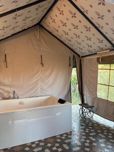 a large tent with a bath tub in it at Jaseelo Camps near Tehri Lake in Chamba
