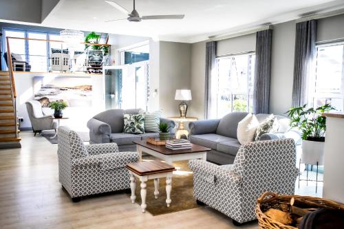 a living room with two couches and a table at Whale Coast Ocean Villa in Hermanus