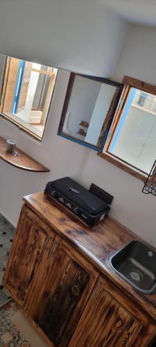 a suitcase sitting on top of a wooden counter with mirrors at Room Taghazout in Taghazout