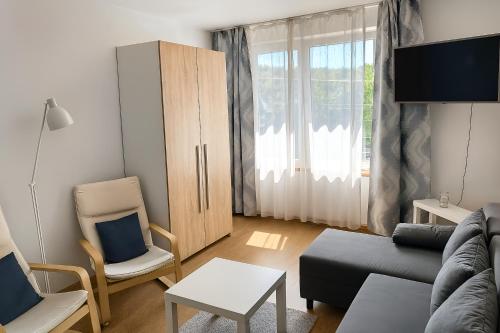 a living room with a couch and a chair at Noclegi Międzylesie - Aktywny Wypoczynek in Międzylesie