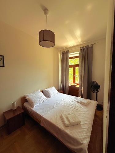 a bedroom with a white bed and a window at Bokeska apartment in Podgorica