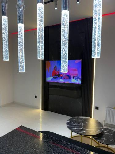 Una habitación con dos sillas y un televisor y luces. en Golden House Luxury, en Toshkent-Passajir Bekati