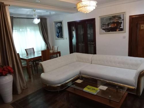 a living room with a white couch and a table at Lake 47 Suites Ltd in Abuja