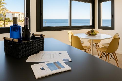 einen Tisch mit einer Flasche Wein und ein Buch in der Unterkunft Apartamento en Ametlla de Mar SEA VIEW HAUS FREE WIFI in L'Ametlla de Mar