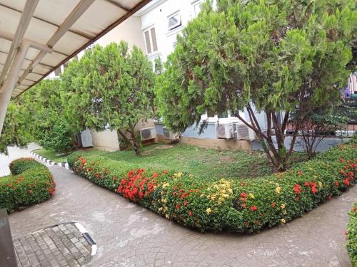 a garden with flowers and trees in a building at Lake 47 Suites Ltd in Abuja