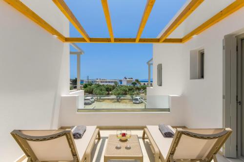 a dining room with a table and chairs and a large window at Porto Drio Seaside Residence in Drios