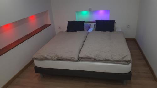 a bed in a small room with lights on it at Gîte dans maison ardéchoise de caractère in Beaumont