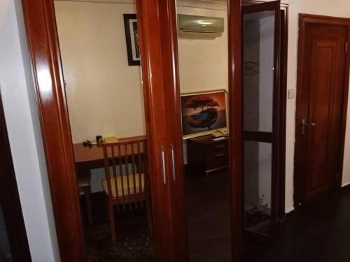 an open door to a room with a table and a desk at Lake 47 Suites Ltd in Abuja