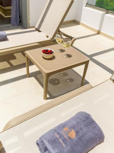 a table on a patio with a bowl of fruit and wine glasses at Porto Drio Seaside Residence in Drios