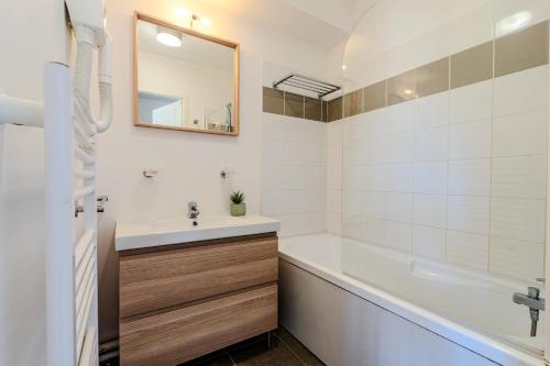 un bagno con un lavandino, una vasca e uno specchio di Appartement de type 2 cabine pour 4 personnes a Parentis-en-Born