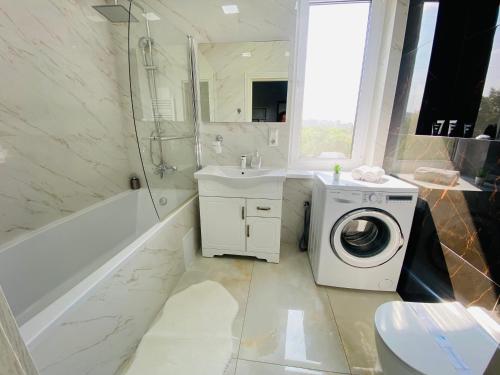 ein Badezimmer mit Waschmaschine und Waschbecken in der Unterkunft Apartament Chisinau in Chişinău