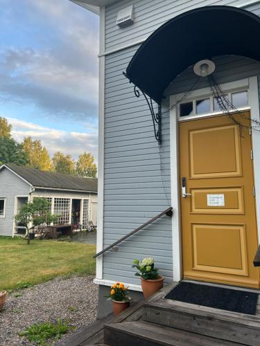 a house with a yellow door on the side of it at Cozy 1 Br Apt and Free parking by the Railway station in Oulu