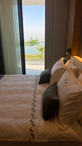 a bed with pillows with a view of the ocean at RUKA Hotel in Narlıdere