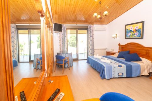 a bedroom with a bed and a table and chairs at Hostal Los Rosales in Alcaraz