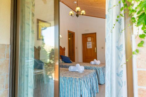 a room with two beds and a mirror at Hostal Los Rosales in Alcaraz
