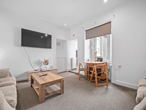a living room with a table and a desk at Ludgate 2 Bedroom Apartment - Alloa in Alloa