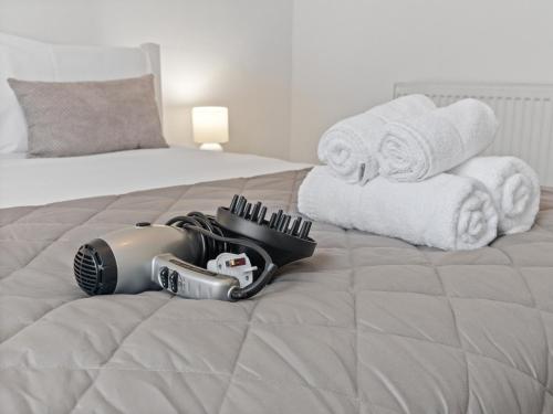 a helmet is laying on a bed with towels at Ludgate 2 Bedroom Apartment - Alloa in Alloa