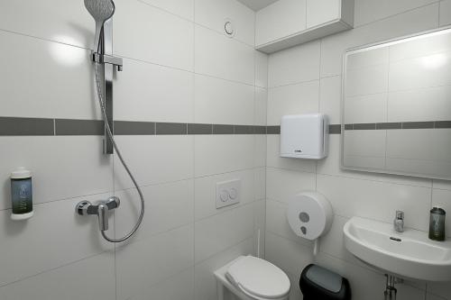 a bathroom with a shower and a toilet and a sink at Hotelkonkurrenz Hostel in Nürnberg