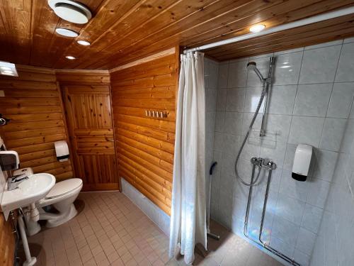 a bathroom with a shower and a toilet and a sink at Motelli Rovaniemi in Rovaniemi