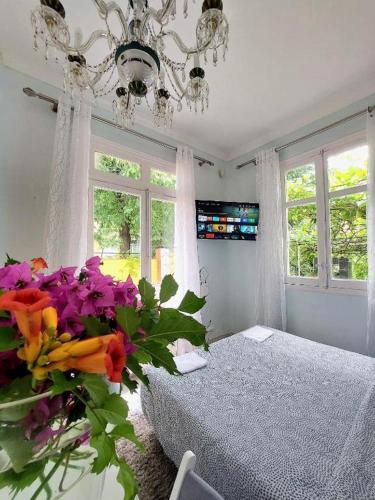 a bedroom with a bed and a chandelier and flowers at Casa Dolores - ECOline accomodation in Madrid