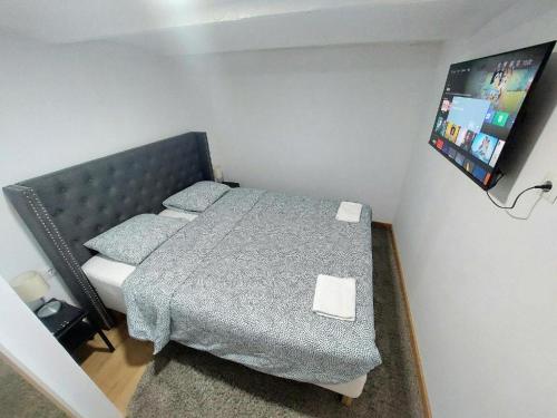 a small bedroom with a bed and a flat screen tv at Casa Dolores - ECOline accomodation in Madrid
