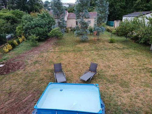 an aerial view of a yard with two chairs and a pool at La maison sous le pont in Puy-lʼÉvêque