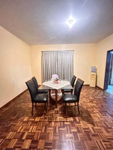 a dining room with a table and four chairs at Hospede-se ao lado do Alles Park in Pomerode