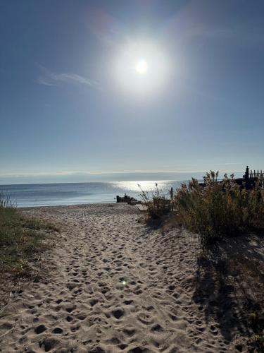 a sandy beach with the ocean in the background at coastal and cozy beach stay, pet friendly in Milford