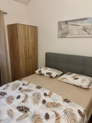 a bedroom with two beds and a headboard at Sun Place Bigova in Bigova