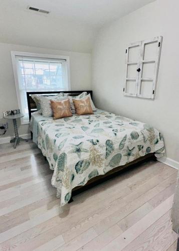 a bedroom with a bed with a comforter and a window at coastal and cozy beach stay, pet friendly in Milford