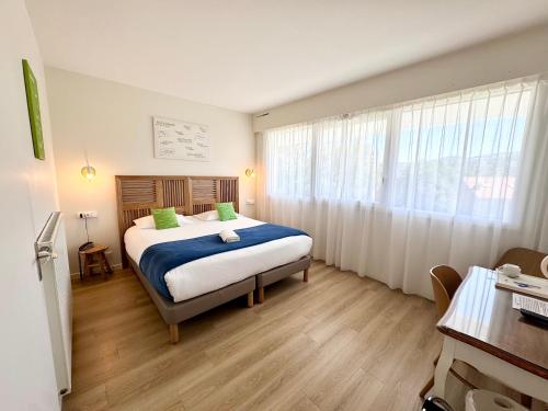 サン・テティエンヌにあるHotel ASTORIA- Saint Etienne-Centre des Congrès-の部屋の中に大きなベッドがある寝室
