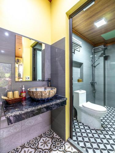 a bathroom with a bowl sink and a toilet at Cozy Son Hotel in Ninh Binh