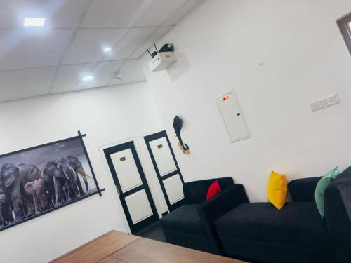 a living room with a couch and a bird on the wall at Black & White Elephant Lobby in Mahiyangana