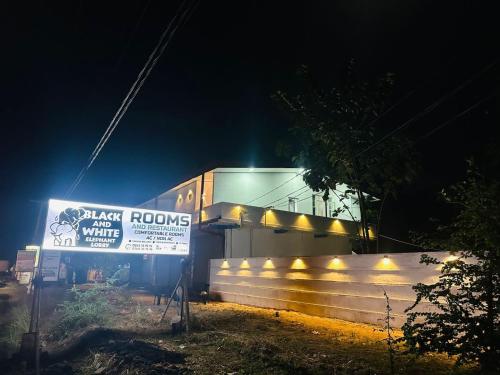 a building with a sign in front of it at night at Black & White Elephant Lobby in Mahiyangana