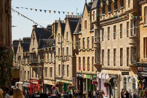 a group of buildings on a city street with people at NYX Hotel Edinburgh in Edinburgh