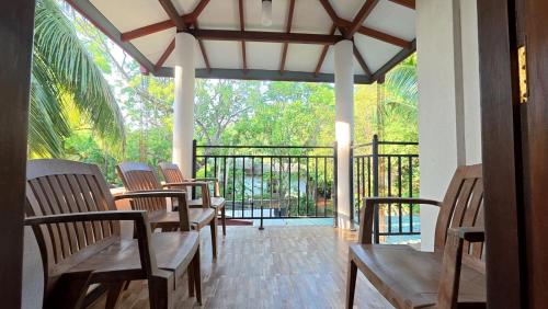 a porch with chairs and a balcony with a view at Kumara Guest House in Anuradhapura