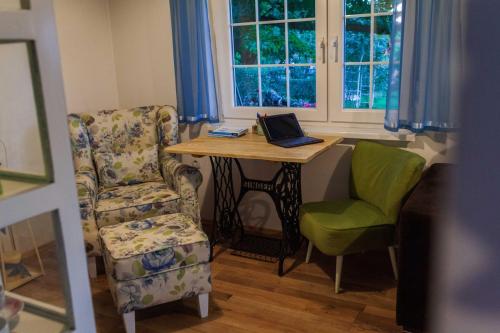 a room with a table and a chair and a laptop at Bajkovnik in Čortanovci