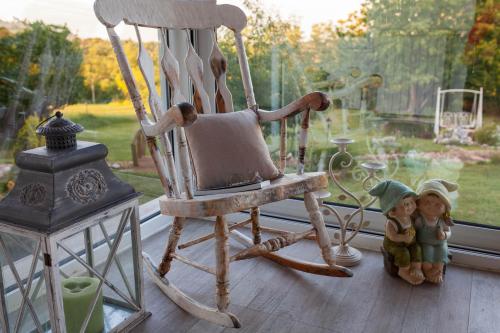 a rocking chair and two dolls on a window sill at Bajkovnik in Čortanovci